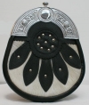 The SPORRAN is black leather with a Celtic cantle, a white cowhide base on the front overlayed with leather detailing and studs.
